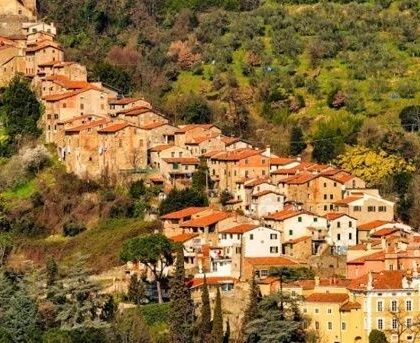 Collodi tegen een groene Toscaanse heuvel met terracottadaken