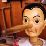 Houten Pinokkiofiguur met een lange neus in een werkplaats
